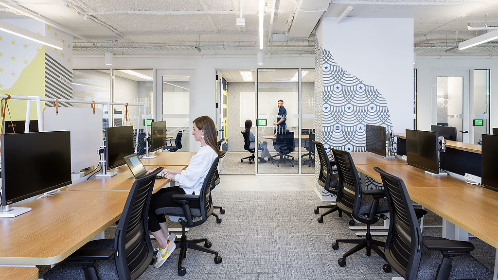 People sitting at a table with computers.